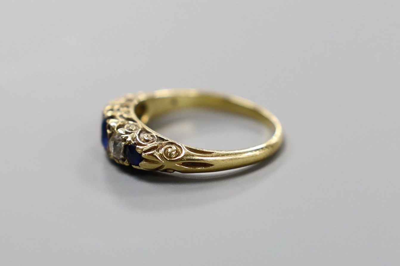 A yellow metal, three stone sapphire and two stone diamond set half hoop ring, with carved setting, size K, gross weight 3.6 grams.